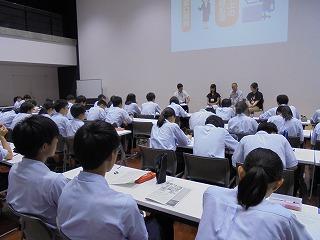 スライドを説明している若手職員たちと、座って聞いている生徒たちの写真
