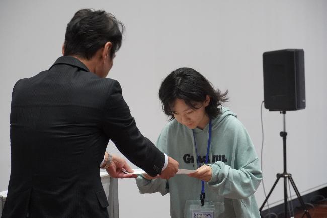 長善館学習塾閉講式で教育長から修了証を受け取る塾生