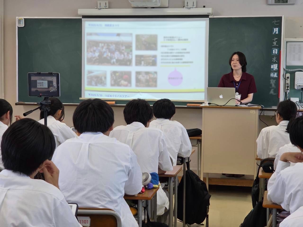 燕市職員が吉田高校生徒に燕市役所まちあそび部の活動を説明している写真。