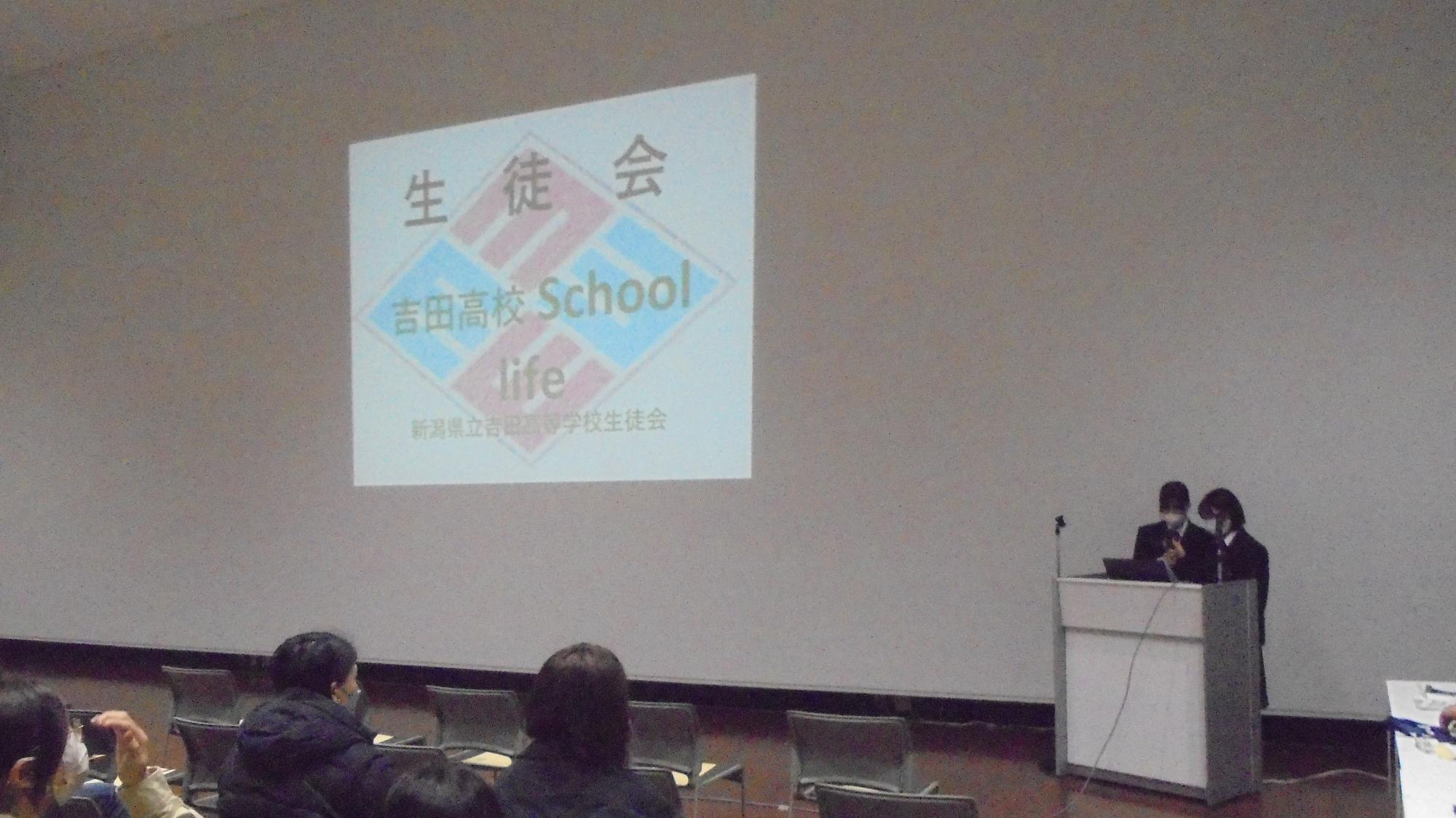 吉田高校生が学校紹介の説明をしているところ