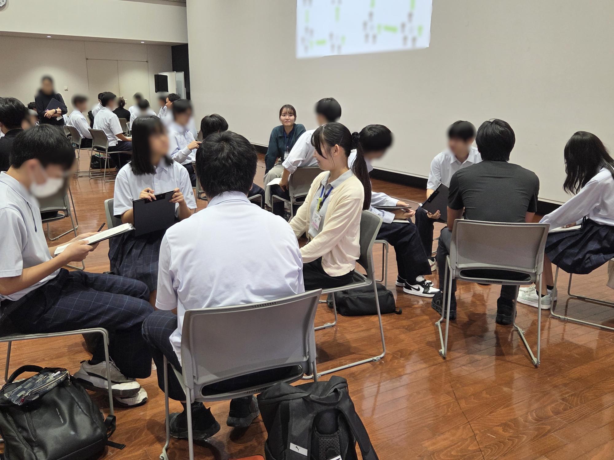 分水高校生が若手職員に質問している写真。