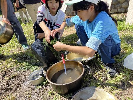 長善館学習塾の塾生がキャンプで鍋を洗っている様子