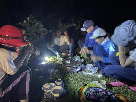 長善館学習塾の塾生がキャンプで真っ暗の中ご飯を食べる様子