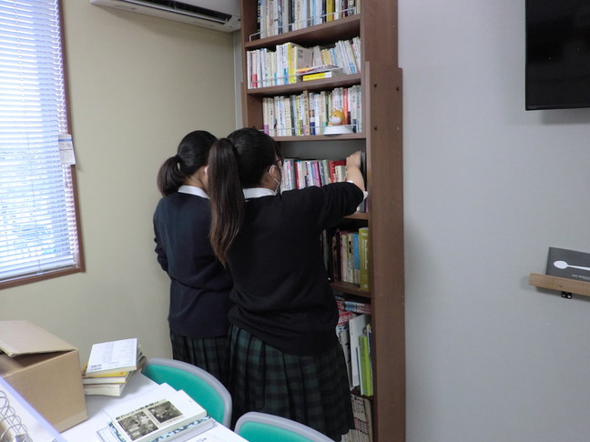 生徒が職場環境の整備、本棚の整理をしているところ。