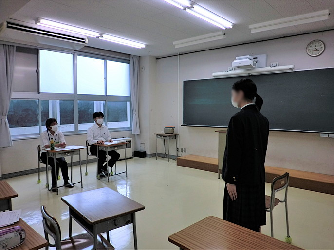 面子の開始時、女子生徒が入室して、椅子に座る前に、2人の面接官に礼をしているところ。