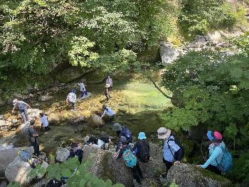 長善館学習塾キャンプでみんなで一列になって沢渡りをする様子