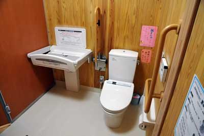 おむつ交換用のスペースがある木目の壁の多目的トイレの様子