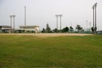 芝生と屋街灯のあるソフトボール場の写真