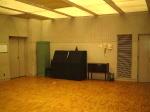 壁側面にピアノやロッカーが配置されている練習室の写真