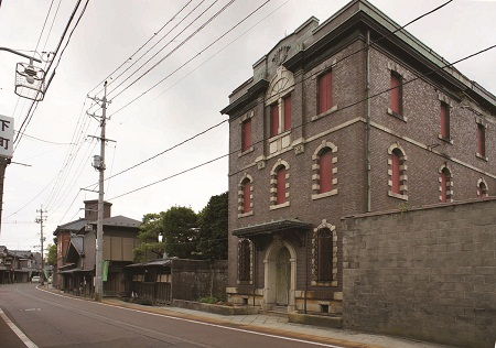 丸い窓と入り口のある茶色いレンガ造りの建物の写真