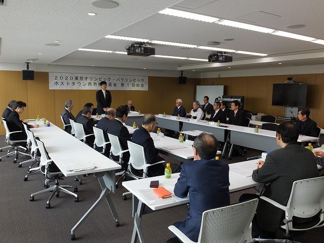 会議室に集まったスーツ姿の委員たちを撮影した委員会の全景写真