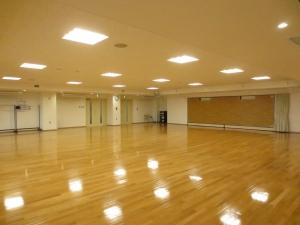 光沢のある床と天井にある四角い照明が特徴の中ホールの写真