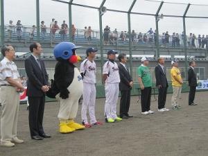 野球場でつば九郎や野球選手や野球関連の人たちが並んで立っている写真