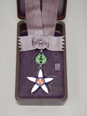 箱に収められた花のような形の勲章の写真