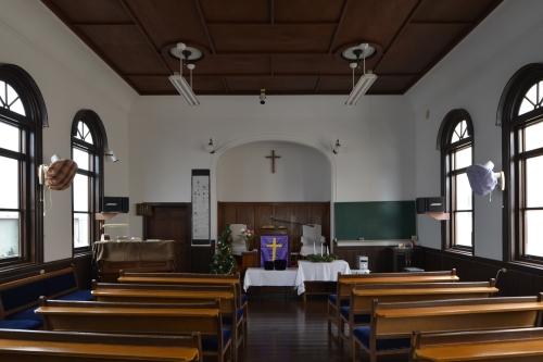 横長の椅子が並び、奥に祭壇がある2階の礼拝所の写真