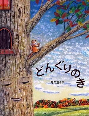 青い空と木とリスのキャラクターが描かれた絵本「どんぐりのき」の表紙