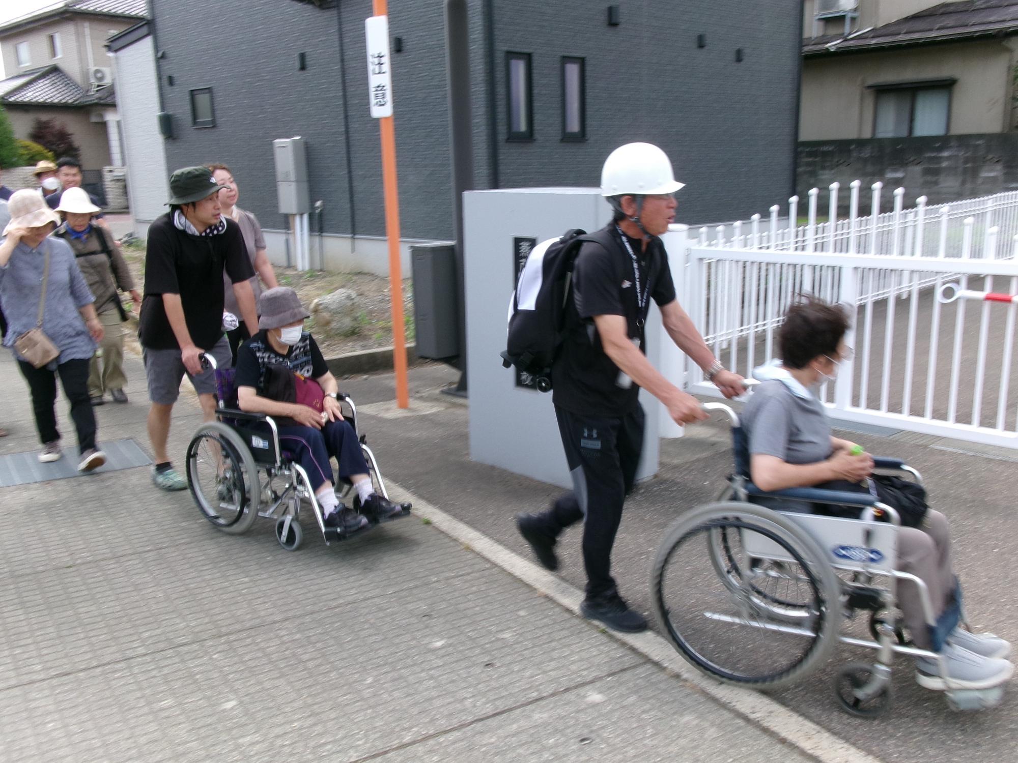 車いすで要援護者を運んでいる様子1