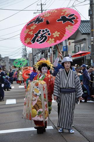 和服の衣装に身を包んだ人たちが列を成して練り歩いている写真