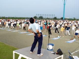 グラウンドに集まり、体操をする参加者たちの写真