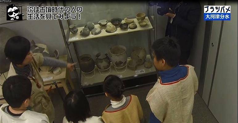 児童と大人がケースに入った展示物を眺めている「ブラツバメ」ワンシーンの写真