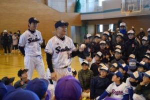 野球のユニフォームを着た児童たちが熱心に話を聴いている写真