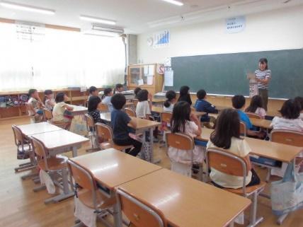 教室で児童たちに向けて話をする先生の写真