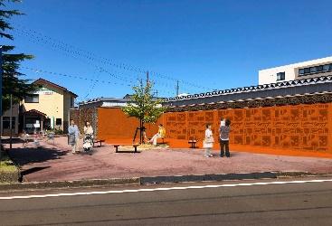 デザインが施されたオレンジ色の壁を見学している人たちの写真