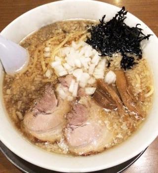 チャーシューとメンマと刻みタマネギがトッピングされた背脂ラーメンの写真