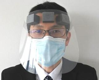 透明のフェイスシールドとマスクを着用した男性の写真