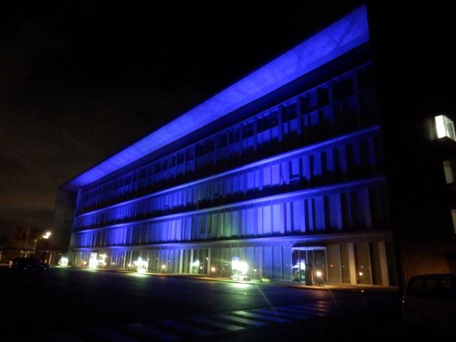 ブルーのライトで壁一面照らされた燕市役所本庁舎の写真