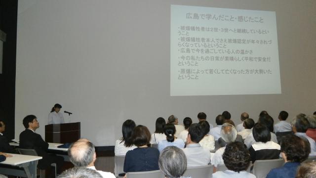 「広島で学んだこと・感じたこと」のスライドを発表している女子生徒と、座って聞いている参加者たちの写真