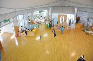 フローリングで広い床の子育て支援センターで子供たちが遊んでいる写真