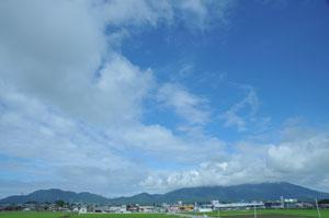 弥彦山の上空に白い雲が広がっている様子の写真