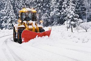 黄色い除雪車が道路上の雪を掻き出している様子の写真
