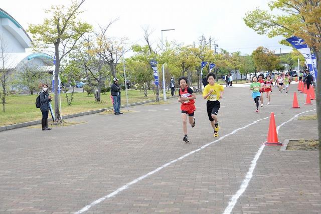 赤服と黄色服のランナーが競い合って走っている写真