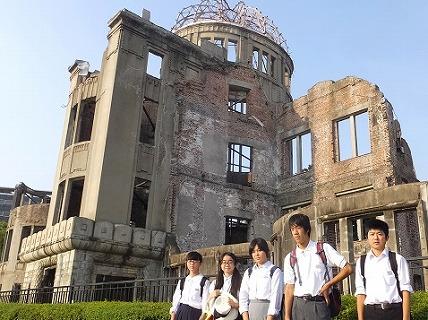 原爆ドームを背景にリュックを背負った男女生徒5人が映る集合写真