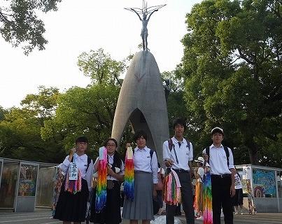 原爆の子の像を背景に色とりどりの千羽鶴を持っている男女生徒5人の写真