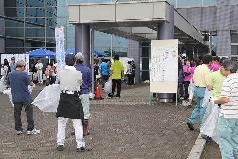 燕市市役所の入り口付近で大会「クリーンアップ選手権」の参加者たちが集まっている写真