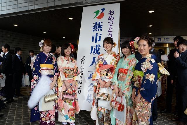 「おめでとう燕市成人式会場」と書かれた看板の前で各々色の違う振袖姿の5人の女性が並んでいる写真