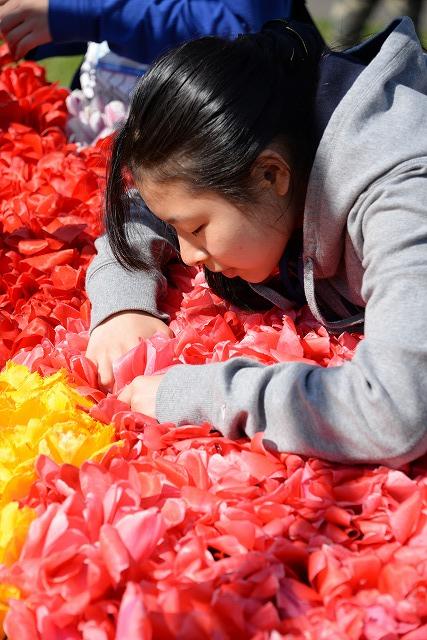 花絵創作のためチューリップをパネルに挿す参加者の女の子の写真