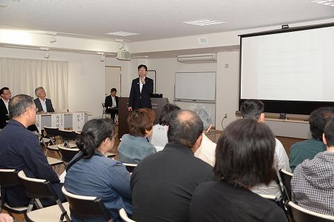 参加者たちに向い「医療や道路網、住環境」などについて語る鈴木市長の写真
