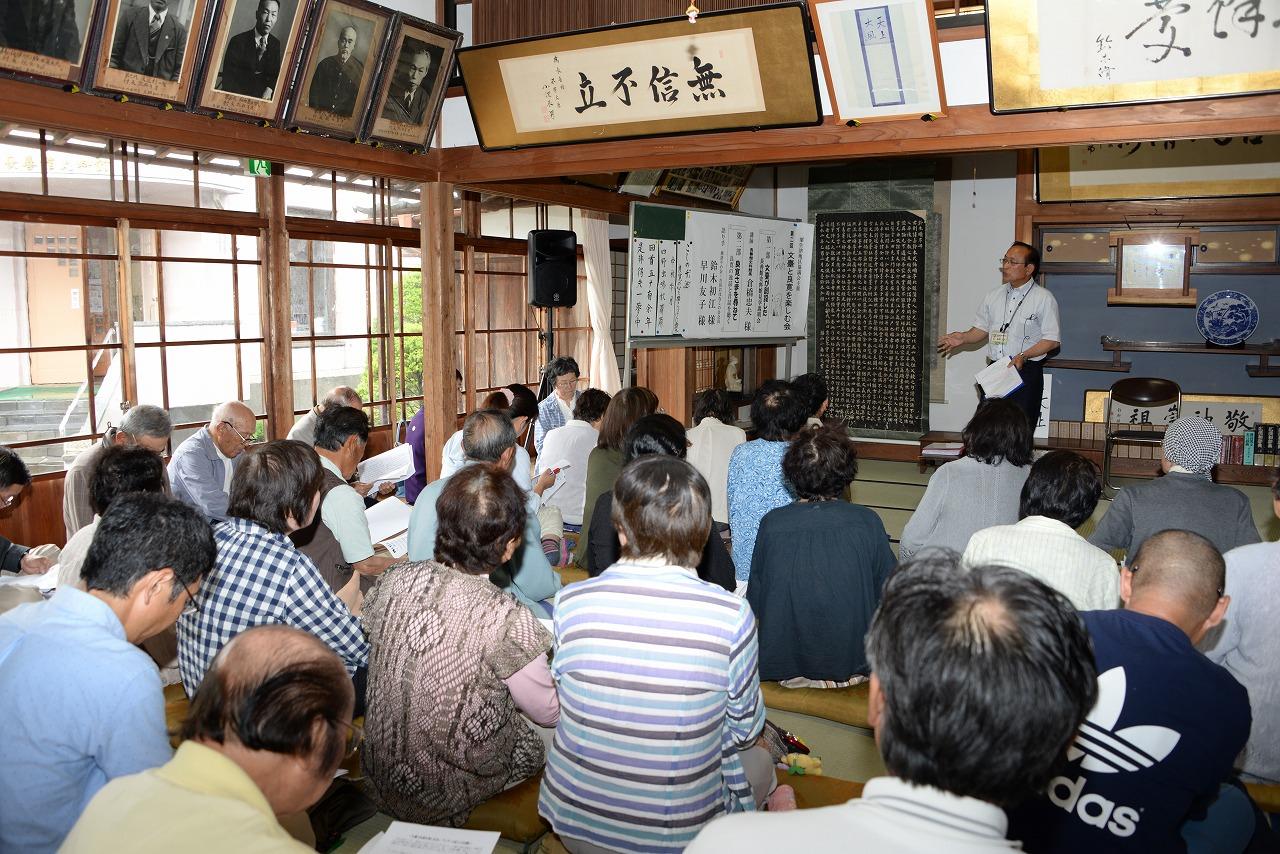 館内で説明会で倉橋館長から「文臺の書、石碑」の説明を受けているたくさん参加者たちの写真