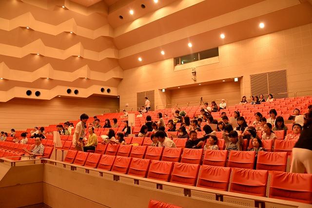 燕市文化会館のオレンジ色の客席ホールで「コンテスト」を鑑賞しに集まった子どもや親御さんたちの様子