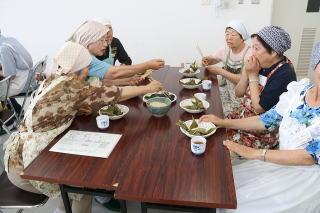 年配の女性たちが笹団子とちまきを食べている写真
