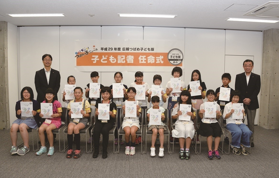子ども記者任命式において任命証を両手に持って記念撮影している写真