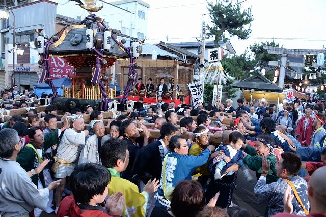 一際、大きい主神輿を担ぐ大勢の人々でごった返す神社の様子を写した写真