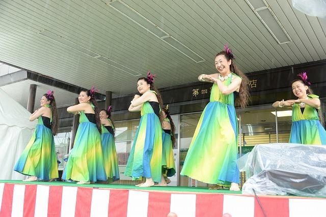 第四銀行燕支店の前で、フラダンスを披露している7人の女性の写真