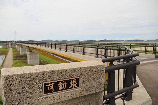 信濃川に架かる、巨大な可動堰へと至る橋梁の様子を写した写真