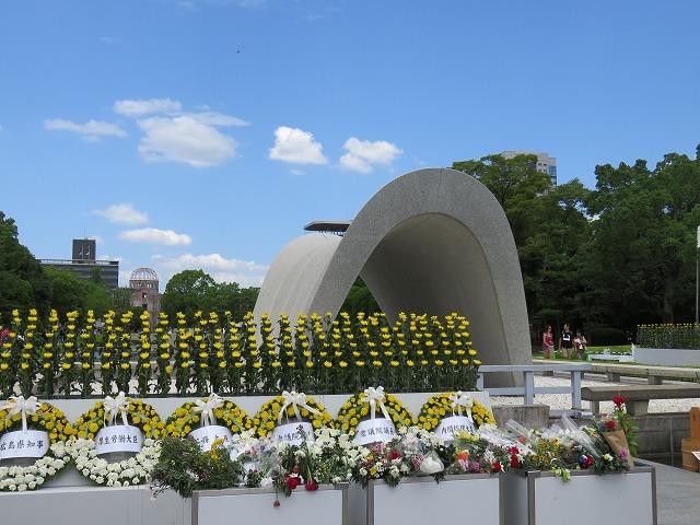 8月6日の平和記念式典会場に供えられた花々と慰霊碑の写真