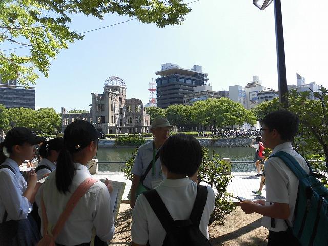 ボランティアガイドとともに平和記念公園散策する中学生たちの写真